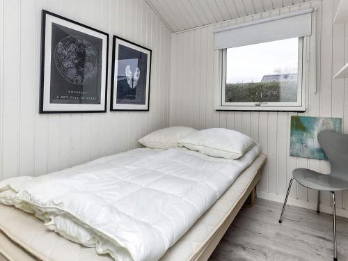 Bett in einem Zimmer mit drei Bildern an der Wand in der Unterkunft Holiday home Karrebæksminde XXXIX in Karrebæksminde