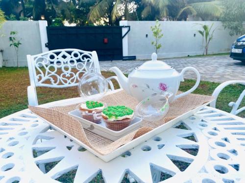 - un plateau avec des petits gâteaux et un service à thé sur une table dans l'établissement TwinsTop Villa, à Minuwangoda
