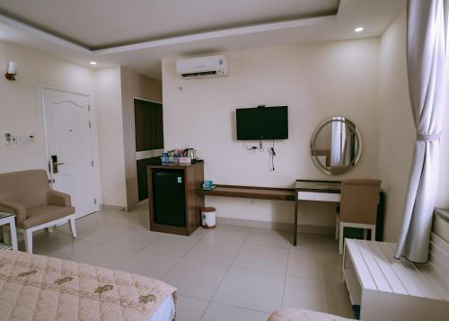 a room with a bed and a desk and a mirror at Thuan Phat House Soc Trang in Soc Trang