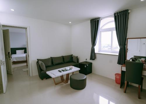 a living room with a green couch and a table at Thuan Phat House Soc Trang in Soc Trang