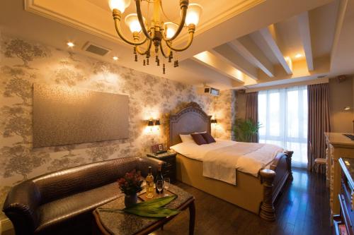 a bedroom with a bed and a couch and a chandelier at Canon Himeji Higashi (Adult Only) in Himeji