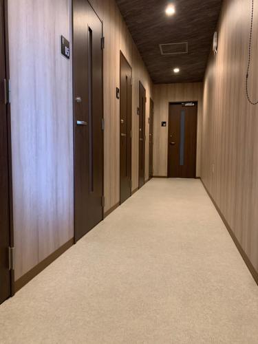 an empty hallway with wooden doors and a corridorngthngthngthngthngthngthngth at BEPPU ROJIURA stay&sauna in Beppu