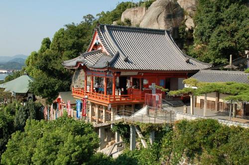 a house with an asian roof on top of a hill at HOUS-AGALonomichi in Onomichi