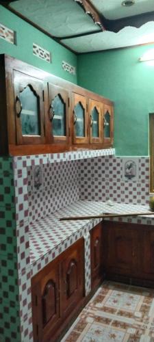 a bathroom with sinks and mirrors on a green wall at Dino Enjoy Property in Trincomalee