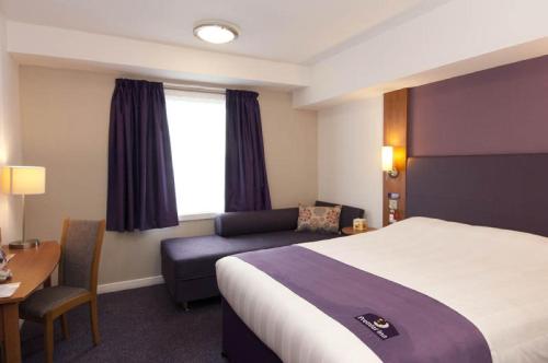a hotel room with a bed and a couch at Premier Inn Dublin Airport in Swords