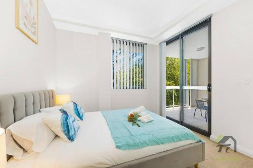 Wonderful Home in Your Heart في Waitara: غرفة نوم بيضاء مع سرير وشرفة
