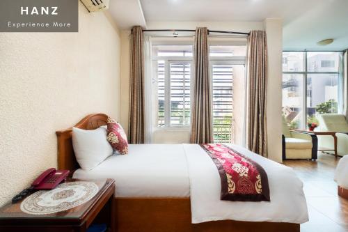 a hotel room with a bed and a window at HANZ Queen Airport Hotel in Ho Chi Minh City