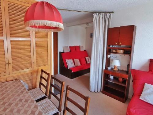 une chambre avec une table à manger et une chambre rouge dans l'établissement Appartement 2 pièces, proche pistes et commerces, balcon, WIFI, parking disponible - FR-1-502-550, à Tignes