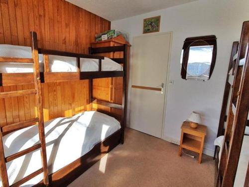 - une chambre avec 2 lits superposés et une porte dans l'établissement Appartement 2 pièces, proche pistes et commerces, balcon, WIFI, parking disponible - FR-1-502-550, à Tignes