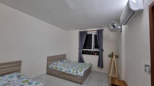 a bedroom with a bed and a window at Apartment Homestay Phan Rang - heri24h (1-6per) in Kinh Dinh