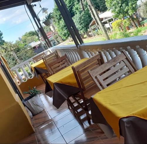 a restaurant with two tables and chairs on a balcony at Hostel Damaris in Puerto Iguazú