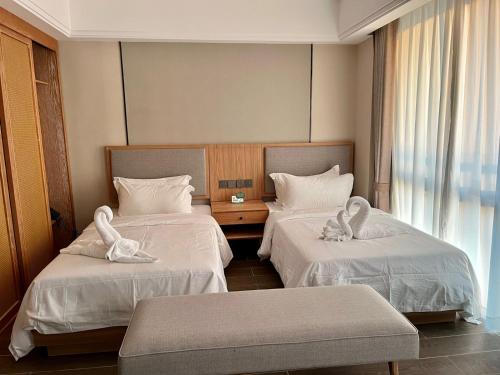een hotelkamer met 2 bedden en handdoeken erop bij NAGA Hotel and Apartment Vientiane in Vientiane