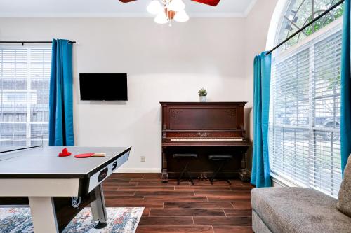 uma sala de estar com uma mesa de pingue-pongue e um piano em Nr Sea World Games Wifi Bbq Yard Pet Ok em San Antonio