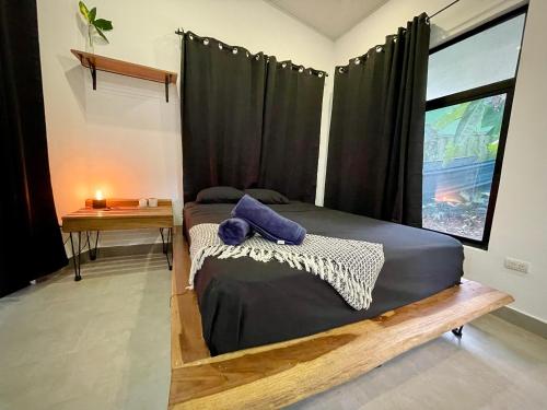 a bedroom with a bed with black curtains and a window at Casa Eden - Modern Peaceful Jungle Apartments in Cocles