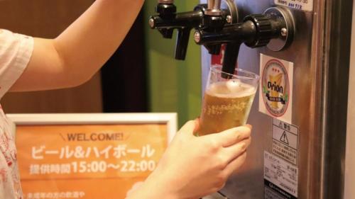 a person is holding a glass of beer at Hotel Art Stay Naha Kokusai-Dori in Naha