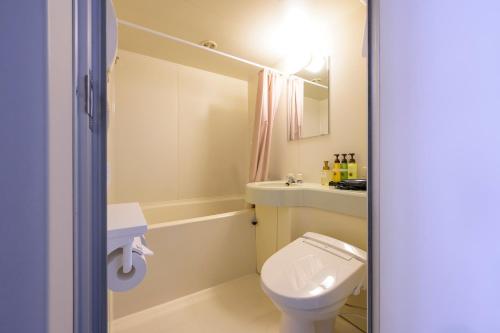 a bathroom with a toilet and a sink at Kotoni Green Hotel in Sapporo