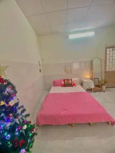 a bedroom with a bed and a christmas tree at Homestay Tuyết Trinh in Nha Trang