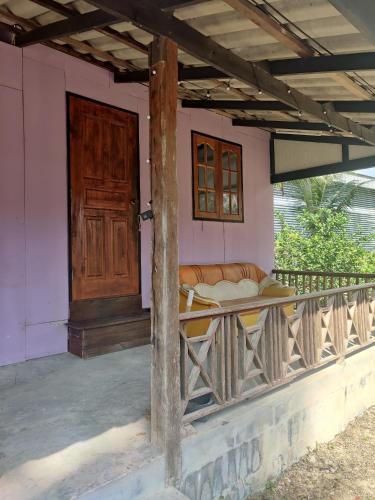 a porch of a house with a couch on it at Thai Style Housing in Koh Phangan