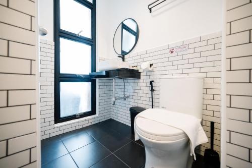 a white bathroom with a toilet and a mirror at Mitt Haus (Lat Phrao Soi 5) in Bang Su