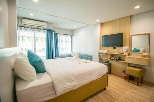 a bedroom with a large bed and a television at Ratana Boutique Resort - Mae Phim in Ban Ang