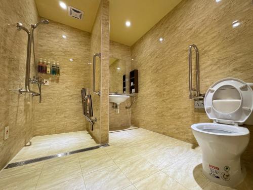 uma casa de banho com um chuveiro, um WC e um lavatório. em Kindness Hotel Wu-Jia em Kaohsiung
