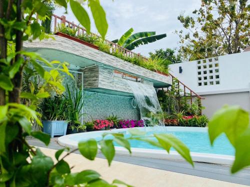 a swimming pool with a waterfall in a garden at Ratana Boutique Resort - Mae Phim in Ban Ang