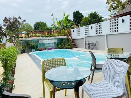 a patio with a table and chairs and a pool at Ratana Boutique Resort - Mae Phim in Ban Ang