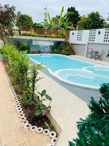 a swimming pool next to a building at Ratana Boutique Resort - Mae Phim in Ban Ang