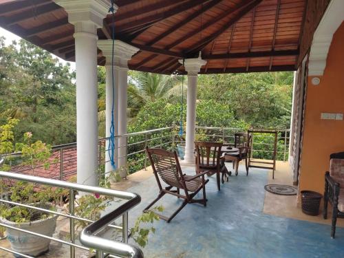 a porch of a house with chairs and a table at Utopia Hikka in Hikkaduwa