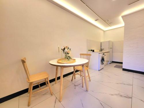 a table and chairs in a room with a kitchen at Seochon Dalbit in Seoul