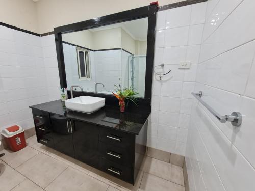 La salle de bains est pourvue d'un lavabo et d'un miroir. dans l'établissement Nasese paradise, à Suva