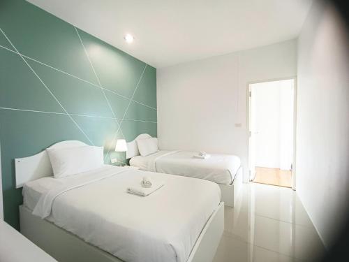 a white room with two beds and a window at Krabi River Cottage Pool Villa in Ban Krabi Yai