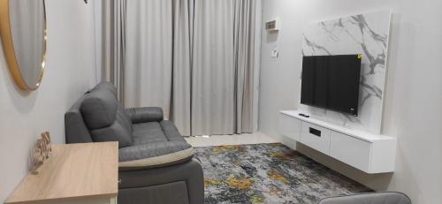uma sala de estar com um sofá e uma televisão em HOMESTAY KHALISH em Gua Musang