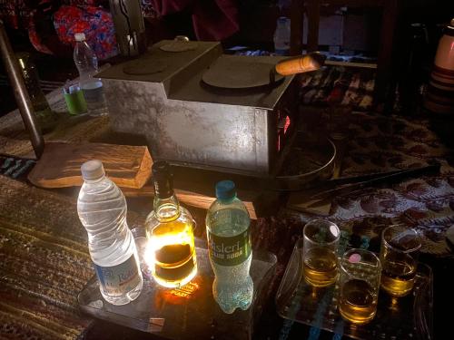 un grupo de botellas y vasos sobre una mesa en Krishna Guesthouse by AttiC Monkey, Old manali next to Drifters cafe, en Manali