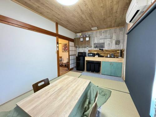 a kitchen with a wooden table in a room at 沼津戸田湾の古民家一軒貸切宿 釣り ハイキング 海水浴 ツーリングにおすすめ in Toda