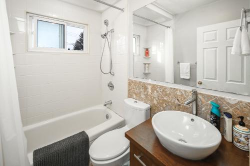a white bathroom with a sink and a toilet at V-Home by Heritage park and Glenmore Reservoir in Calgary