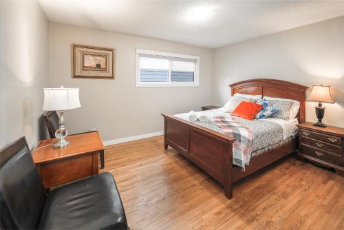 - une chambre avec un lit, un bureau et une chaise dans l'établissement V-Home by Heritage park and Glenmore Reservoir, à Calgary