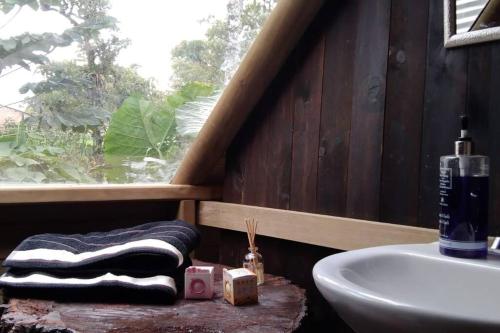 a bathroom with a sink and a towel and a window at Cabaña Bosquecito Escondido in San Pedro