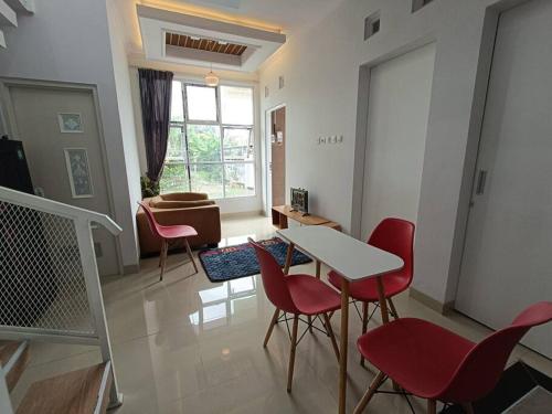 a living room with a table and red chairs at Rumah Dekat Sawah Pemandangan Pegunungan in Kebumen