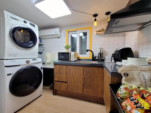 a kitchen with a washing machine and a sink at Residence YeoYu Uijeongbu Station in Uijeongbu