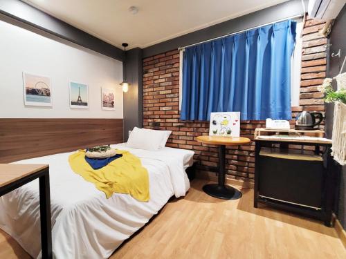 a bedroom with a bed and a brick wall at Residence YeoYu Uijeongbu Station in Uijeongbu