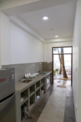 a kitchen with a sink and a tree in the background at Asa Bay Beach Resort in Talpe