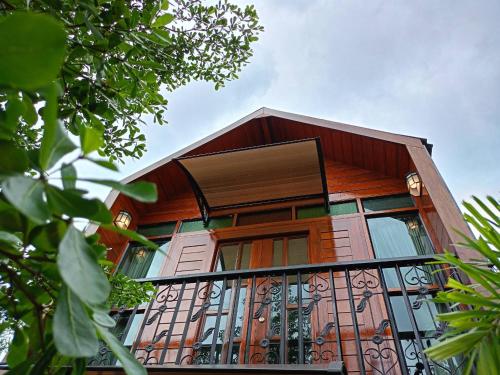 a house with a balcony on the side of it at เรินนายหัว by KOYAD RESORT in Ban Wat Khao