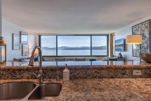 uma cozinha com um lavatório e uma grande janela em Luxurious Lakefront Condo with Lake Views in Brockway Springs Resort Close to Slopes em Kings Beach