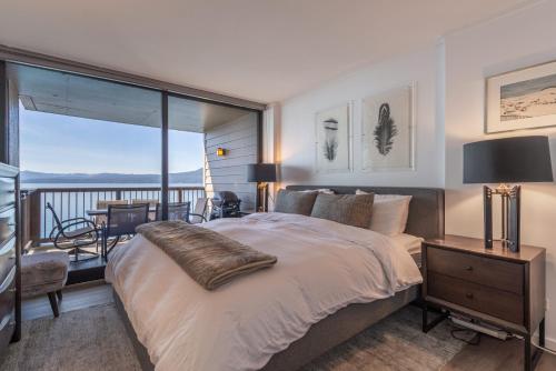 a bedroom with a large bed and a balcony at Luxurious Lakefront Condo with Lake Views in Brockway Springs Resort Close to Slopes in Kings Beach