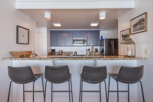 a kitchen with a bar with four stools at VIP Lakefront Condo Amazing Views Pool Pickleball Excellent Location Balcony BBQ in Kings Beach