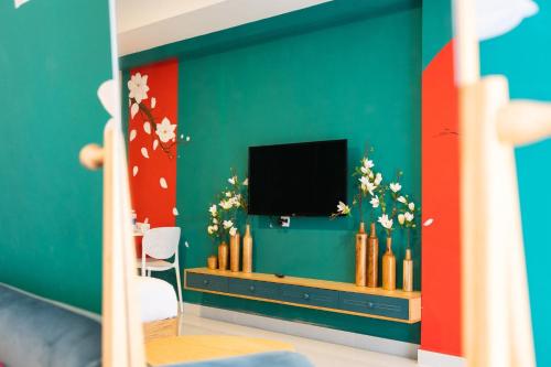 Elle comprend un salon doté d'une télévision et d'un mur vert. dans l'établissement HAYA SOHO SAIGON, à Hô-Chi-Minh-Ville
