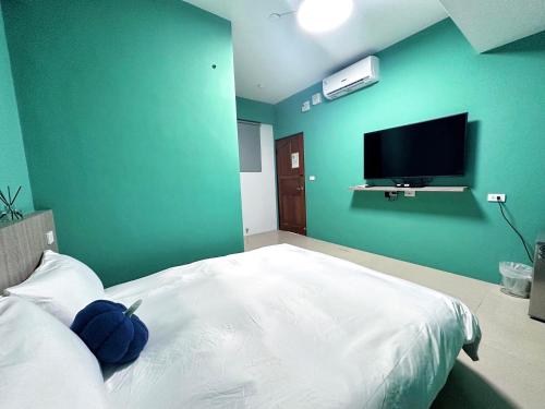 a bedroom with a large bed with a tv on the wall at NuNc in Kenting