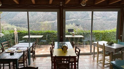 a restaurant with tables and chairs and a large window at Agriturismo La Contessa in Finale Ligure