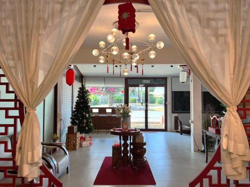 una sala de estar con un árbol de Navidad y una lámpara de araña en Allred Hostel Chiangmai en Chiang Mai